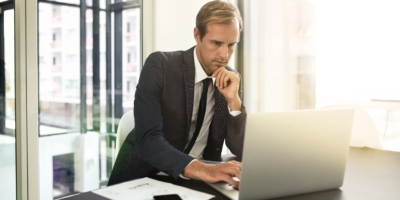 focused task hand shot businessman using his laptop min