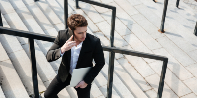 happy young businessman walking outdoors
